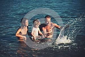 Happy family at a sea having fun and splashing water in summer.