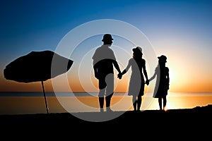 A Happy family by the sea at sunset in travel silhouette in nature