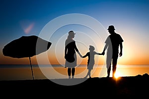 A Happy family by the sea at sunset in travel silhouette in nature