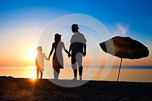 A Happy family by the sea at sunset in travel silhouette in nature