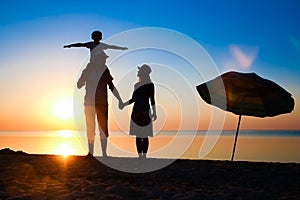 A Happy family by the sea at sunset in travel silhouette in nature