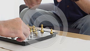 Happy family with senior father playing chess with son together with enjoy on sofa at home