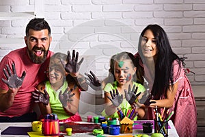 Happy family showing hands colored in paints