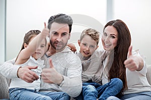 Happy family showing thumbs up.