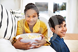 Happy family, siblings and popcorn in portrait in home and relax or bonding together on weekend. Boy, girl and positive