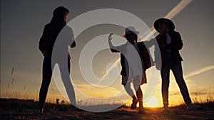 Happy family. Silhouette of group dancing children. Family having fun park at sunset. kid plays with sisters while