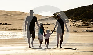 Happy family silhouette at sea beach