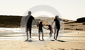 Happy family silhouette at sea beach