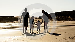 Happy family silhouette at sea beach