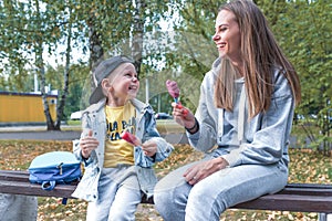 Happy family, sitting bench, mother woman with little boy son 4-5 years old, eat ice cream, support care education