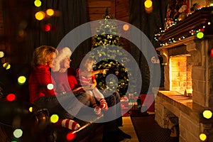 Happy family sitting by fire place at Christmas