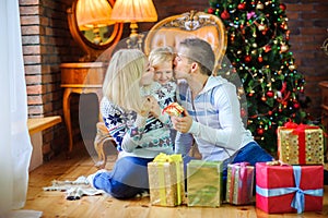 Happy family sitting on the floor near the Christmas tree