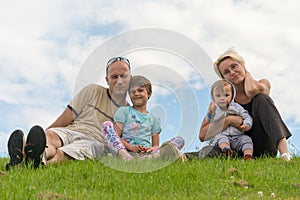 Happy family sitting on the grass