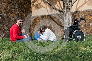 A happy family sitting on the lawn of a park spending the day together