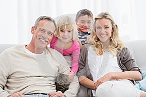 Happy family sitting with pet kitten together