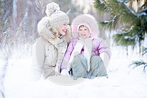 Happy family sitting in snow outdoor wintertime