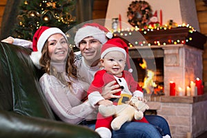 Happy family sitting on sofa near Christmas tree