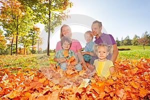 Happy family sitting together on the leaves