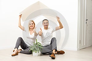 happy family sitting together and making the home sign