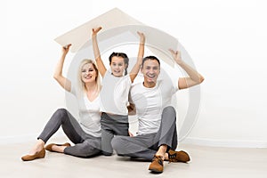 happy family sitting together and making the home sign