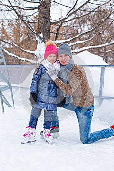 Happy family on skating rink outdoors