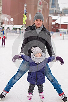 Happy family on skating rink outdoors