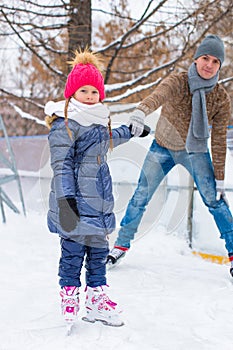 Happy family on skating rink outdoors