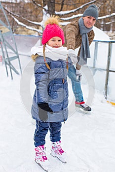 Happy family on skating rink outdoors