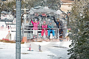 Happy family with ski lift climb up on ski terrain