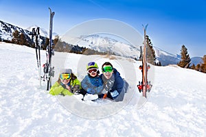 Happy family in ski masks laying on snow