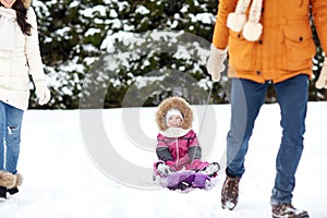 Happy family with sled walking in winter forest