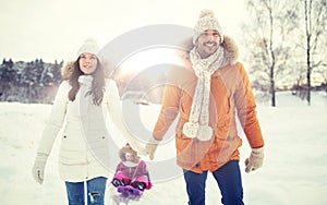 Happy family with sled walking in winter outdoors