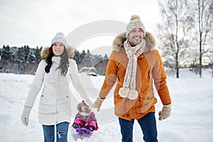 Happy family with sled walking in winter outdoors