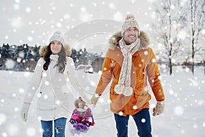 Happy family with sled walking in winter outdoors
