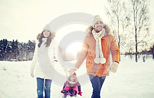 Happy family with sled walking in winter outdoors