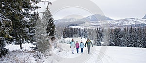 Šťastná rodinka s malými dcérkami na prechádzkach vonku v zimnej prírode, Tatry Slovensko.