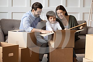 Happy family with small kid unpack boxes on moving day