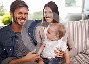 Happy family, smile and relax in sofa mother, father and child at home together. Married couple, parents and playing