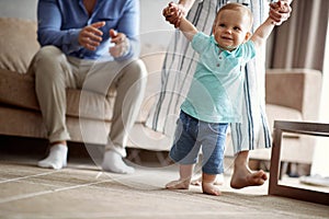 Happy family -Smiling baby boy making first steps photo