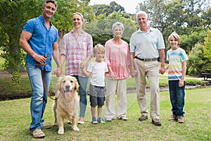 Happy family smiling at the camera with their dog