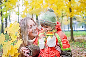 Happy family smiling and holding autumn leaves