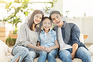 Happy family smiling and hugging on the couch at home