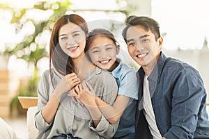 Happy family smiling and hugging on the couch at home