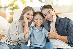 Happy family smiling and hugging on the couch at home