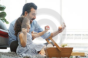 Happy family smiling. Little daughter and father painting colourful Easter eggs