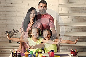 Happy family smiling at table with colorful paints