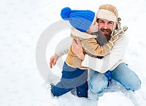 Happy family son hugs his dad on winter holiday. Merry Christmas and Happy New Year. Daddy and boy smiling and hugging.