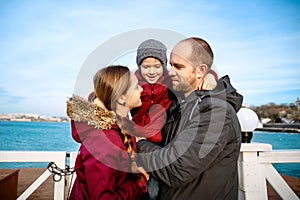 Happy family with son standing at seaside in spring