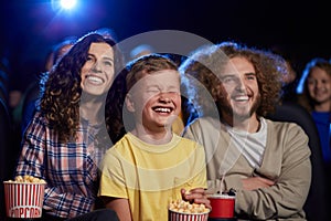 Happy family with son watching cartoon in cinema.