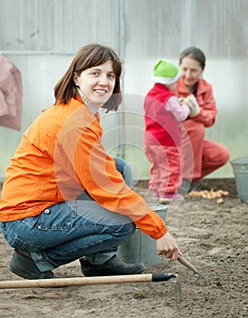 Happy family sows seeds in soil